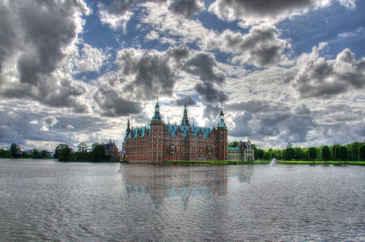 Frederiksborg Castle reflected in the castle lake beneath a dramatic sky